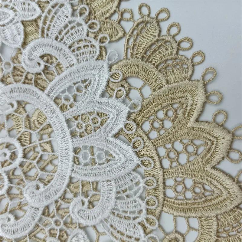 Close-up of the intricate lace fabric from the Costa Rica Coffee Friends brand, with white and beige hues showcasing floral and circular patterns reminiscent of European classical crochet embroidery. The design features delicate, interwoven threads forming symmetrical shapes and fine details, set against a plain background—ideal for their Exquisite Table Mat Bar Counter Wine Glass Coffee Cup Coaster Birthday Party Decoration.