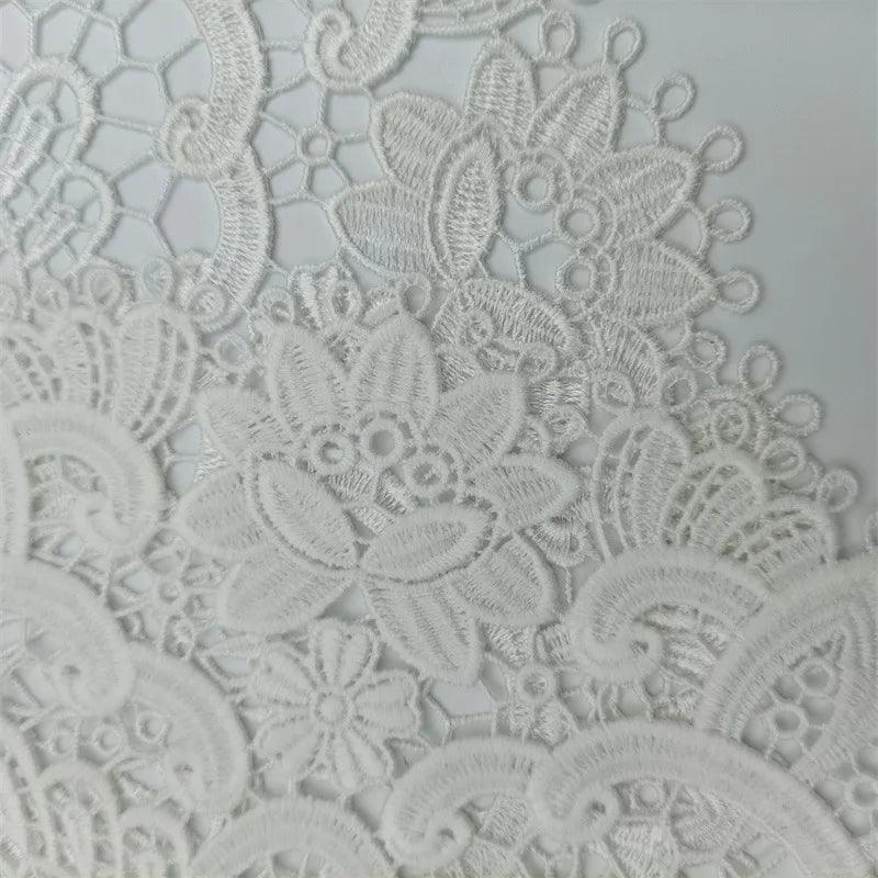 A close-up of the European Classical Crochet Embroidery Exquisite Table Mat from Costa Rica Coffee Friends, showcasing intricate white lace fabric with detailed flower and leaf designs. The light, solid background accentuates the delicate textures and craftsmanship, making it perfect for a bar counter or as a coaster for wine glasses and coffee cups at birthday parties.